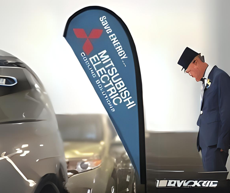 Chauffeur bowing to a Mitsubishi Electric vehicle at a promotional event
